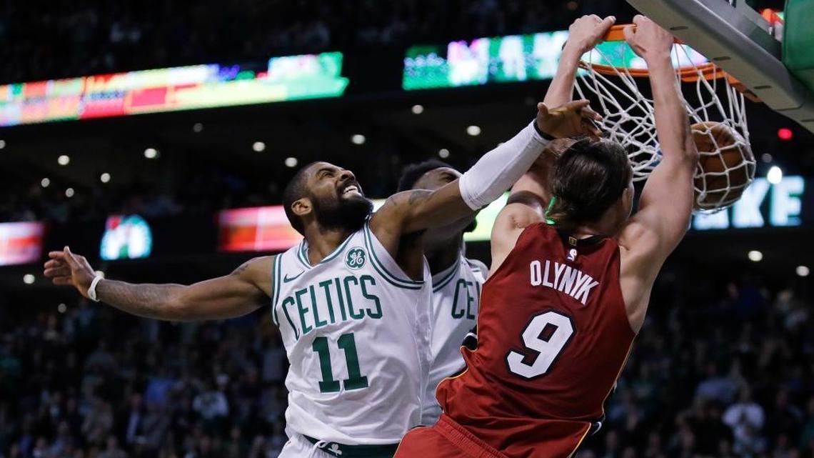 Miami Heat center Kelly Olynyk (9) beats Boston Celtics guard Kyrie Irving (11) to the basket for a dunk during the second half of an NBA basketball game in Boston, Wednesday, Dec. 20, 2017.