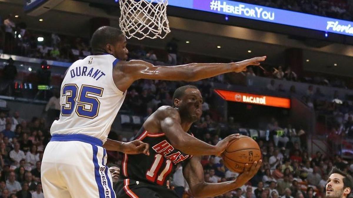 Miami Heat guard Dion Waiters passes the ball against Golden State Warriors forward Kevin Durant during the first quarter of an NBA basketball game at the AmericanAirlines Arena in Miami on Sunday, December 3, 2017.