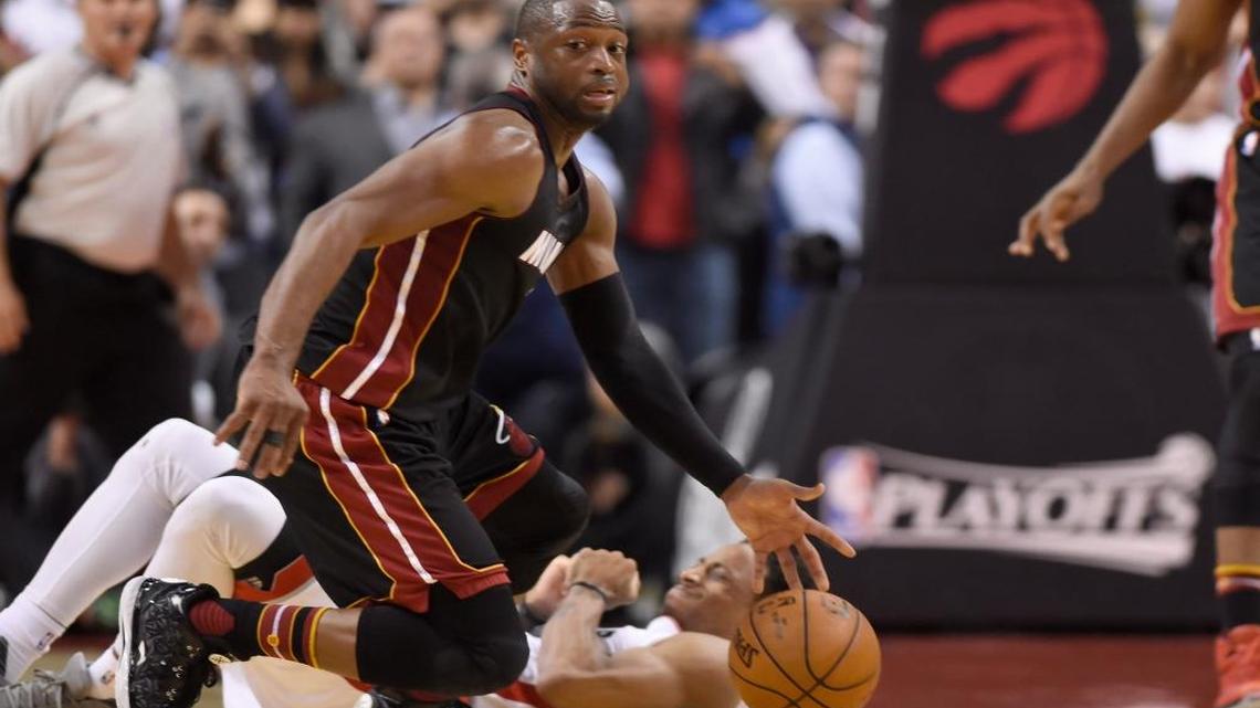 Toronto Raptors' DeMar DeRozan lies on the floor as Miami Heat's Dwyane Wade moves the ball up court during the second half in Game 1 of a second-round NBA basketball playoff series, Tues., May 3, 2016, in Toronto.