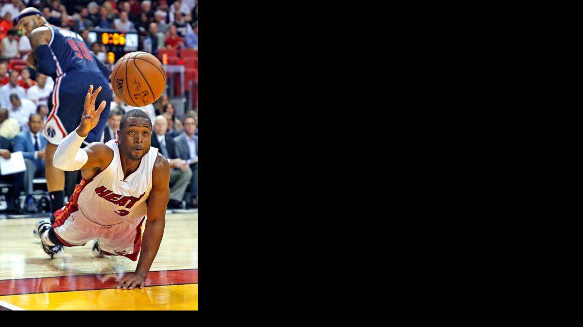 
Miami Heat guard Dwyane Wade (3) chases a loose ball in the third quarter as the Miami Heat hosts the Washington Wizards for the season opener at AmericanAirlines Arena on Wednesday, Oct. 29, 2014.

