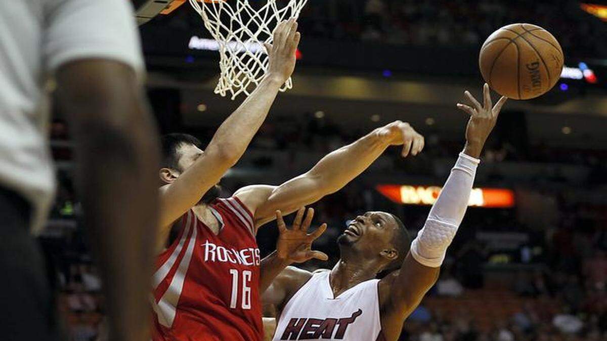 
Miami Heat's Chris Bosh gets blocked by Rockets' Kostas Papanikolaou under the basket in the fourth quarter of the Miami Heat's game against the Houston Rockets at AmericanAirlines Arena in Miami on Tuesday, Nov. 4, 2014.
