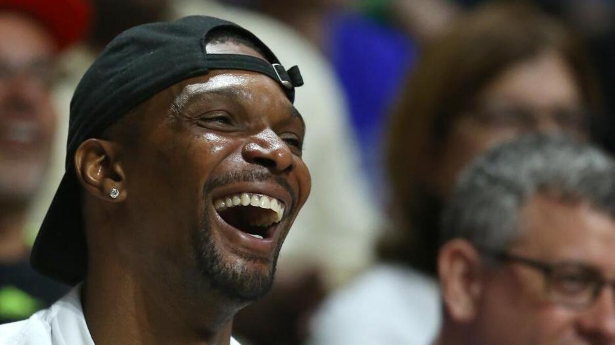 Former Miami Heat forward Chris Bosh smiles during the first half of a college basketball game between the Miami Hurricanes against the Duke Blue Devils in Coral Gables on Feb. 25, 2017.