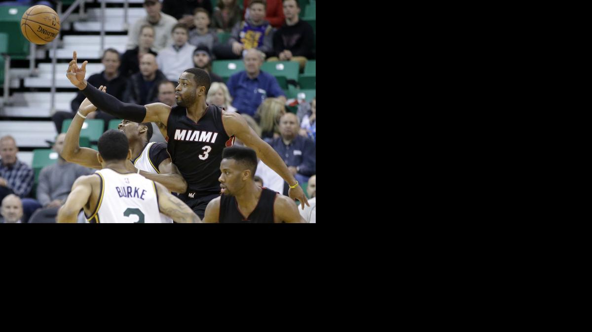 
Miami Heat's Dwyane Wade (3) knocks the ball away from Utah Jazz's Alec Burks, left rear, while Trey Burke (3) looks on in the first quarter during an NBA basketball game Friday, Dec. 12, 2014, in Salt Lake City. 
