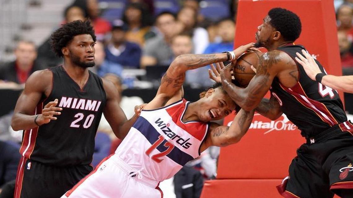 Washington Wizards forward Kelly Oubre Jr. (12) battles for the ball against Miami Heat forward Udonis Haslem (40) and Justise Winslow (20) during the first half of an NBA preseason basketball game, Tues., Oct. 4, 2016, in Washington.