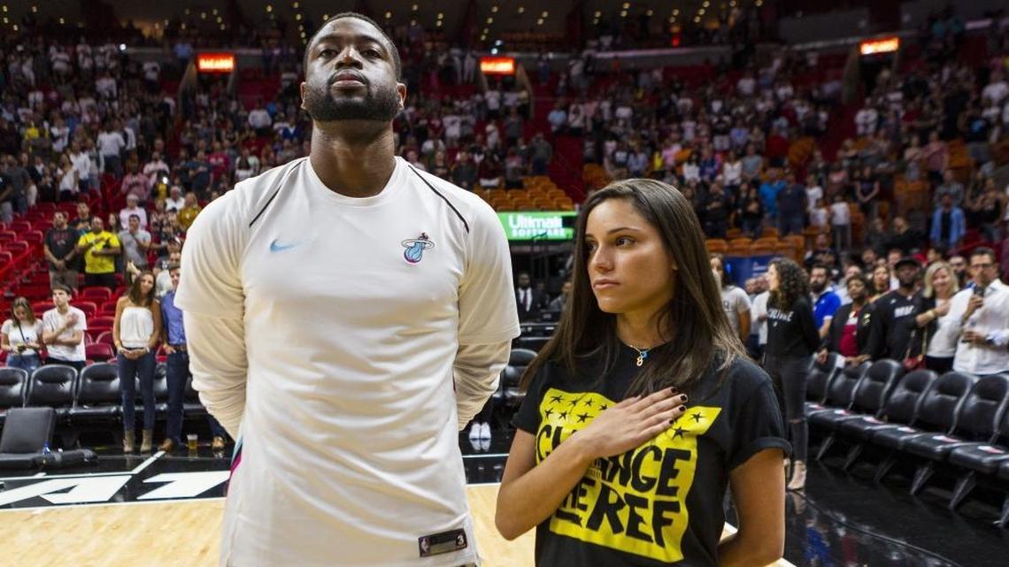 Miami Heat guard Dwyane Wade stands next to Andrea Ghersi, the sister of Joaquin Oliver, 17, who was killed in the Marjory Stoneman Douglas high school shooting, during the singing of the National Anthem before the Heat faced the Pistons at the AmericanAirlines Arena on Saturday, March 3, 2018.