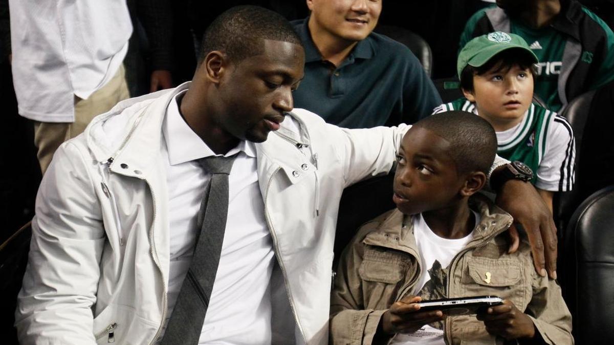 Miami Heat guard Dwyane Wade and son Zaire sit courtside during Game 5 of the NBA Finals between the Boston Celtics and Los Angeles Lakers on Sunday, June 13, 2010, in Boston.