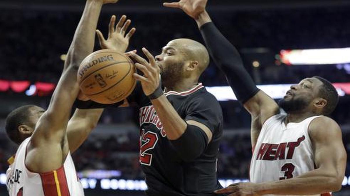 
Miami Heat center Hassan Whiteside (21) and guard Dwyane Wade (3) guard Chicago Bulls forward Taj Gibson (22) during the second half of an NBA basketball game in Chicago on Sunday, Jan. 25, 2015. The Heat won 96-84. 
