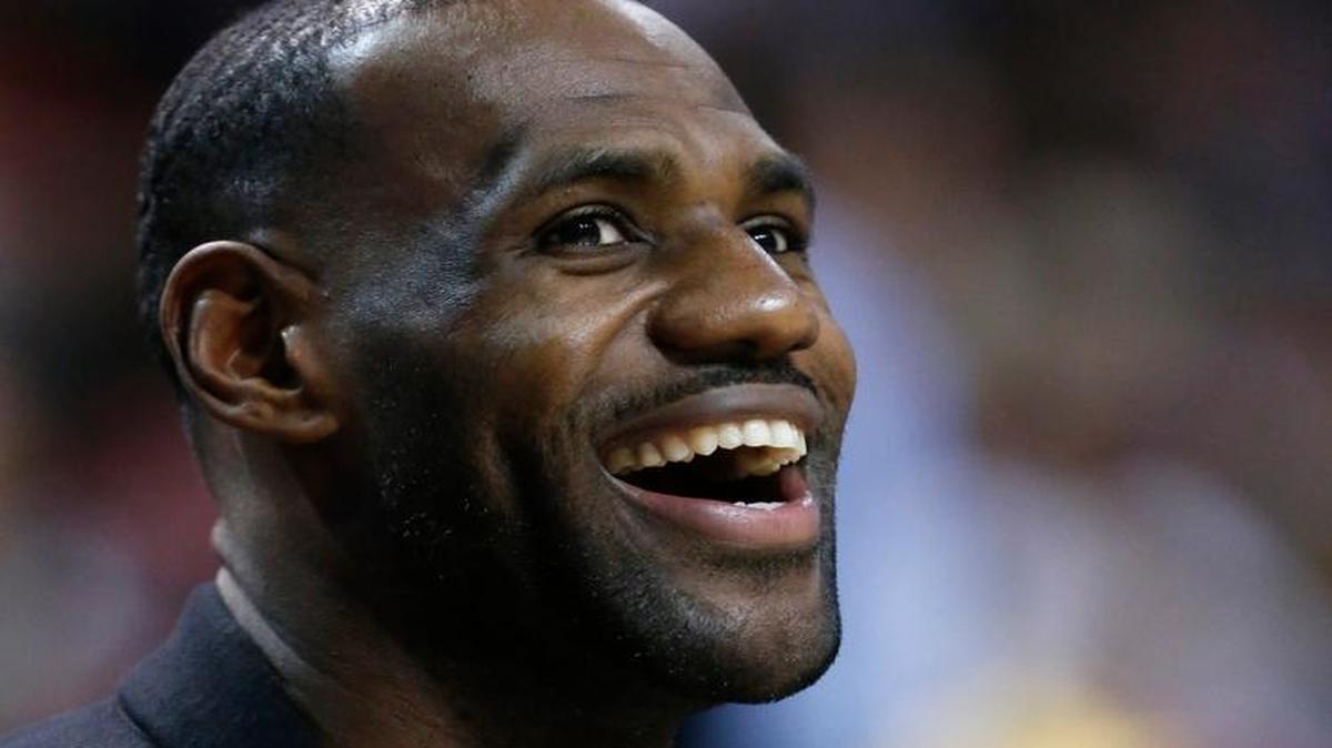 Cleveland Cavaliers' LeBron James smiles as he watches from the bench as he sits out the game during the first half of an NBA basketball game between the Miami Heat and the Cavaliers, Saturday, Dec. 5, 2015, in Miami. Cavaliers coach David Blatt says he made the decision in part because James logged 45 minutes in Cleveland's overtime loss at New Orleans on Friday night.