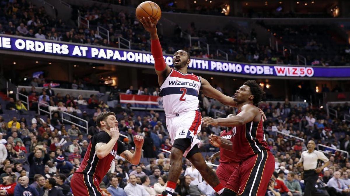Washington Wizards guard John Wall (2) shoots between Miami Heat guard Tyler Johnson, left, and forward Justise Winslow during the second half Wednesday, Jan. 20, 2016, in Washington. The Wizards won 106-87.
