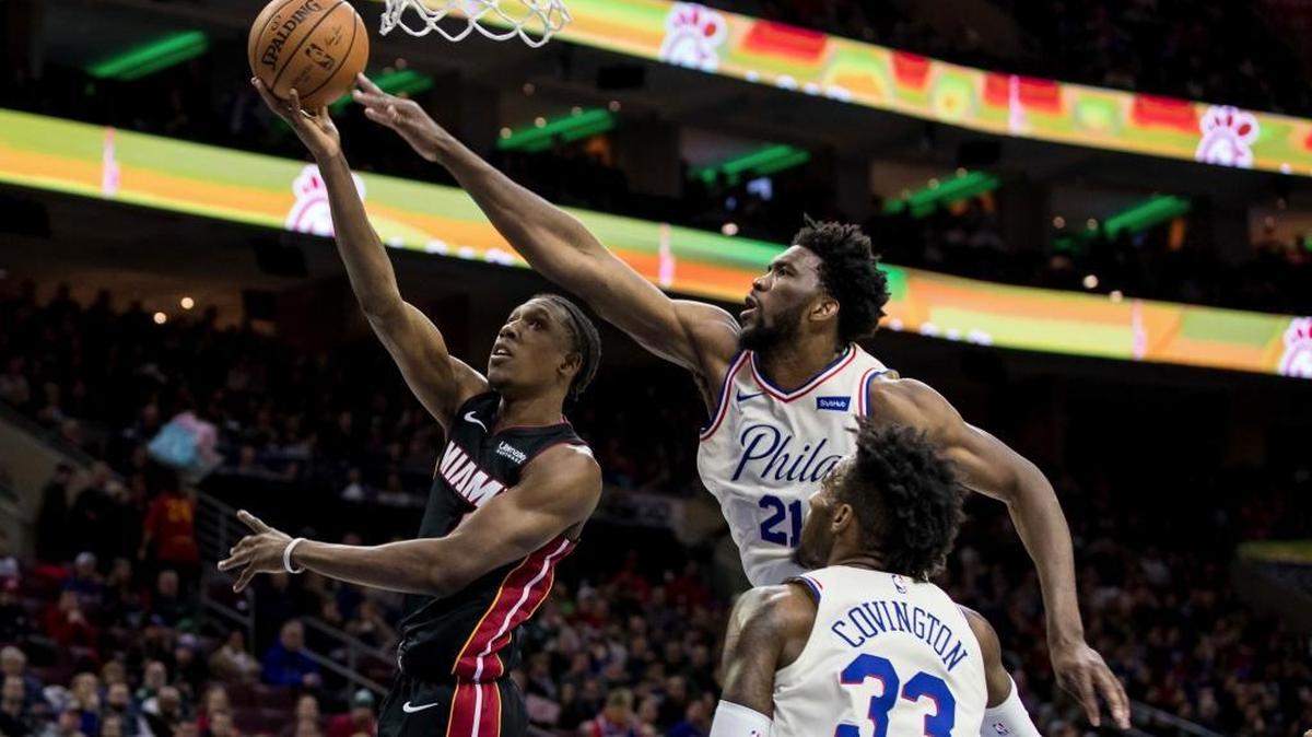 Miami Heat's Josh Richardson, left, shoots as Philadelphia 76ers' Joel Embiid, center, defends while Robert Covington, right, watches during the first half of an NBA basketball gam Friday, Feb. 2, 2018, in Philadelphia.