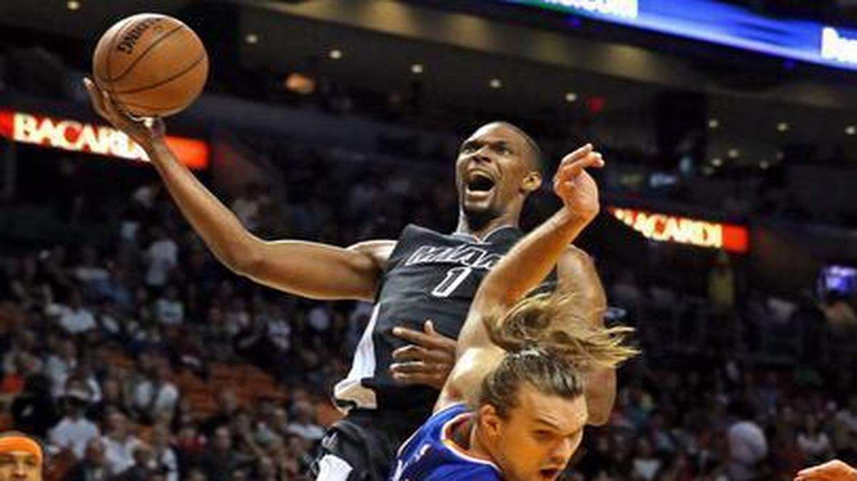 
Heat forward Chris Bosh knocks over the Knicks’ Lou Amundson on a drive to the basket in the first quarter of Miami’s victory Monday night at AmericanAirlines Arena.
