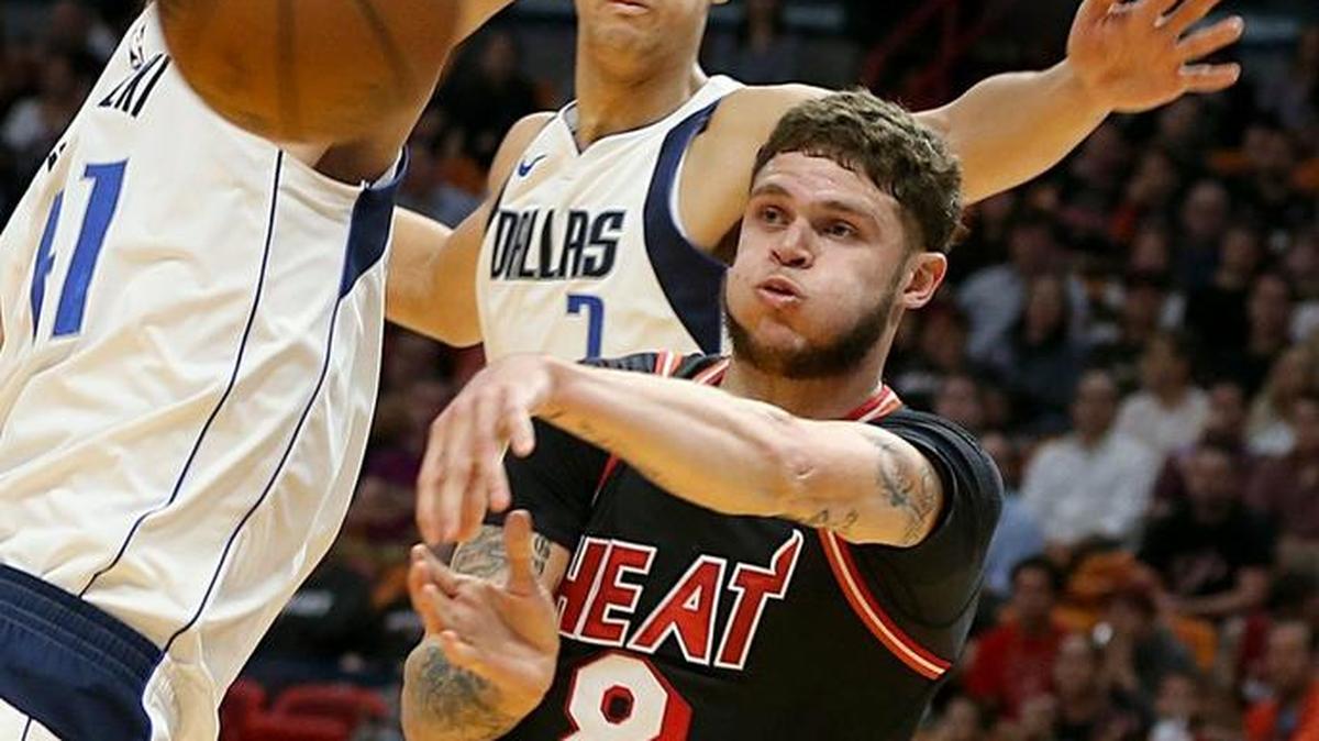 Miami Heat guard Tyler Johnson passes the ball under the basket against Dallas Mavericks forwards Dirk Nowitzki and Dwight Powell in the first quarter of their game at AmericanAirlines Arena in Miami on Dec. 22, 2017.