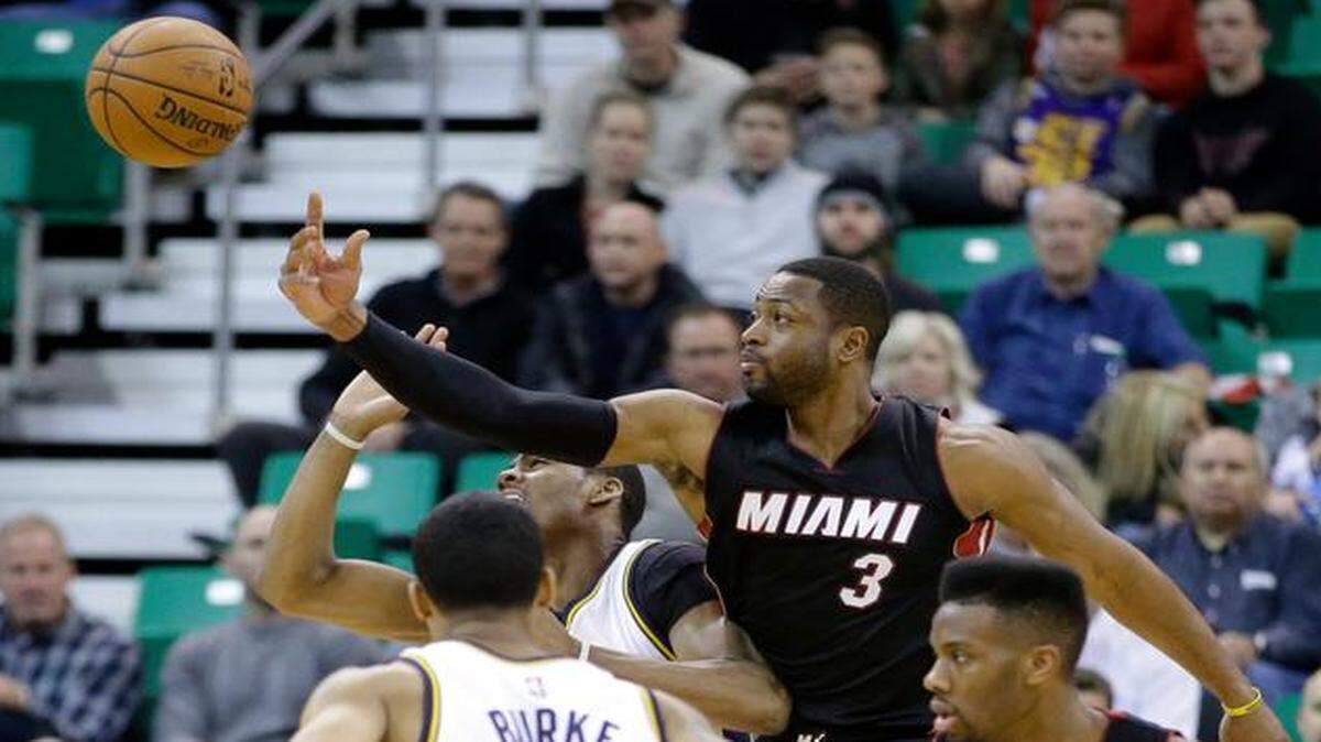 
The Heat’s Dwyane Wade (3) knocks the ball away from the Jazz’s Alec Burks, left rear, while Trey Burke looks on in the first quarter of their game at EnergySolutions Arena, Friday, Dec. 12, 2014.
