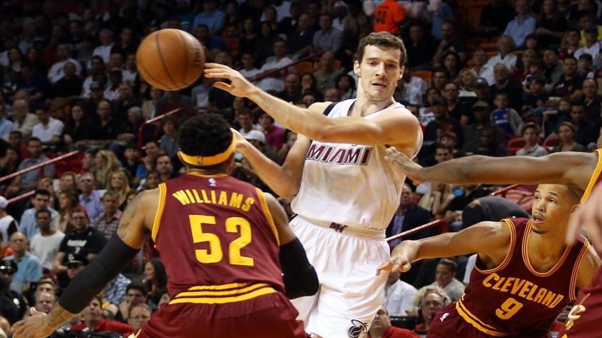 Goran Dragic of the Miami Heat passes the ball over Mo Williams and Jared Cunningham of the Cleveland Cavaliers in the second quarter of a game at AmericanAirlines Arena in Miami on Saturday, December 5, 2015.