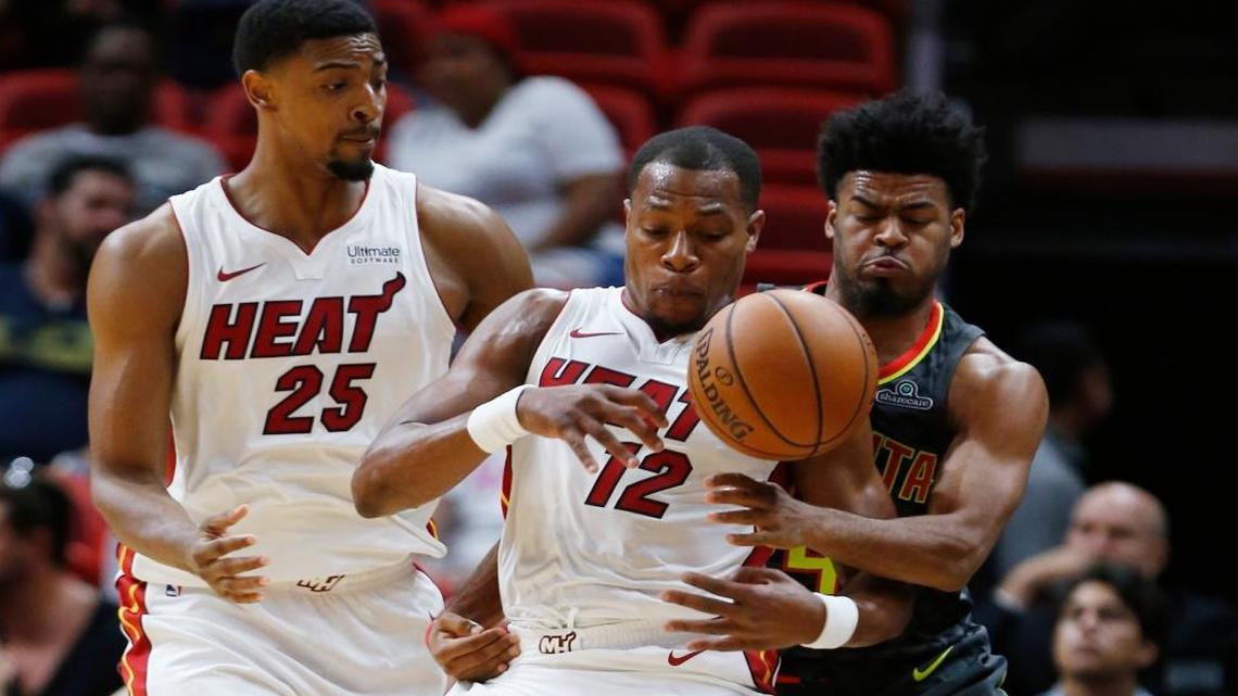 Miami Heat guard Matt Williams (12) attempts to regain control of the ball as he is guarded by Atlanta Hawks guard Quinn Cook, right, while passing forward Jordan Mickey (25) during the second half of an NBA preseason basketball game, Sun., Oct. 1, 2017, in Miami. The Heat defeated the Hawks 96-90.