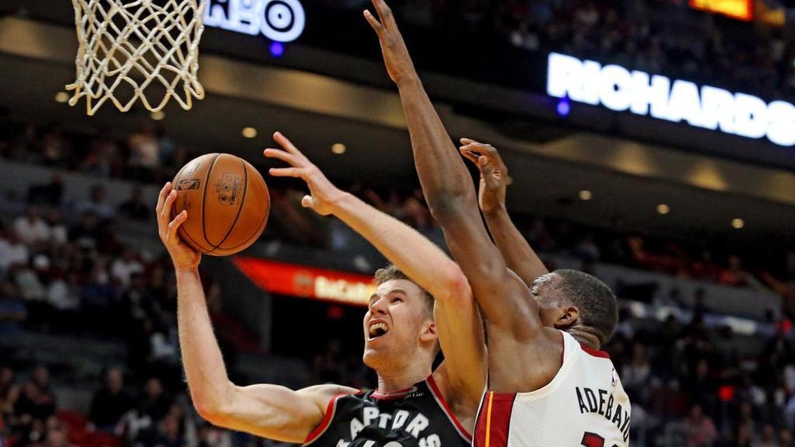 The Miami Heat's Bam Adebayo defends Toronto Raptors' Jakob Poeltl in overtime under the basket at the AmericanAirlines Arena in Miami, Florida, April 11, 2018.