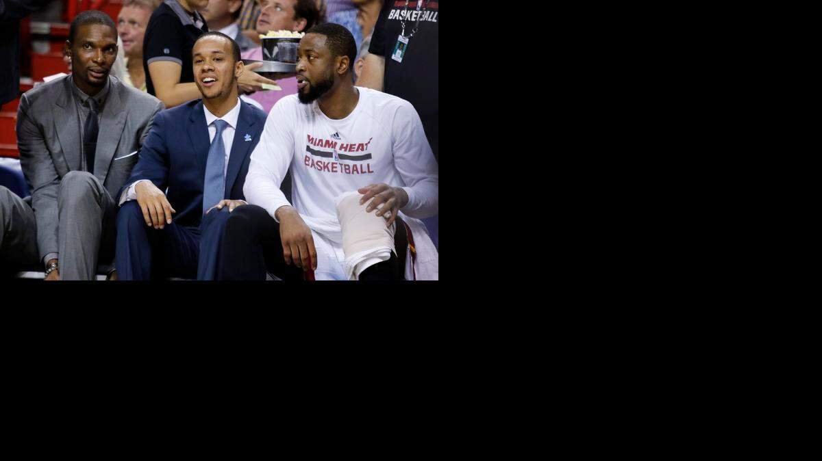 
Miami Heat guard Shabazz Napier, center, sits with teammates Chris Bosh, left, and Dwyane Wade as the Heat plays the San Antonio Spurs on Tuesday, March 31, 2015, in Miami. 
