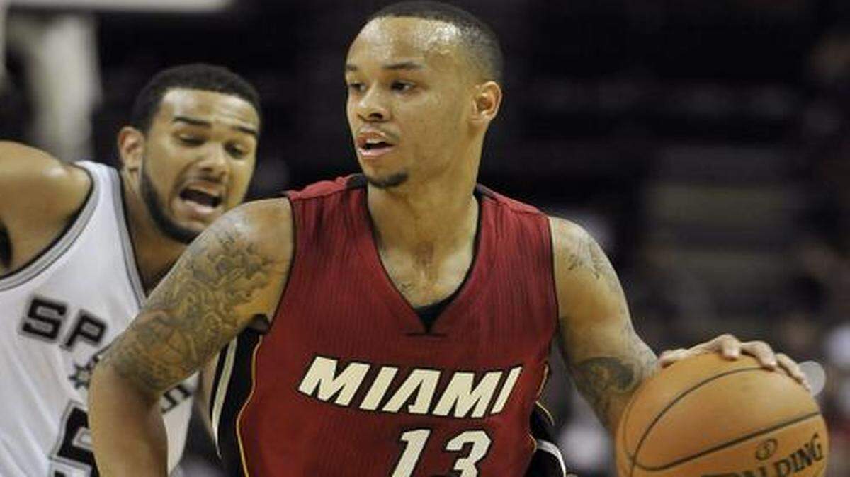 
Miami Heat guard Shabazz Napier (13) drives around San Antonio Spurs guard Cory Joseph during overtime in a preseason game, Saturday, Oct. 18, 2014, in San Antonio. Miami won 111-108. 
