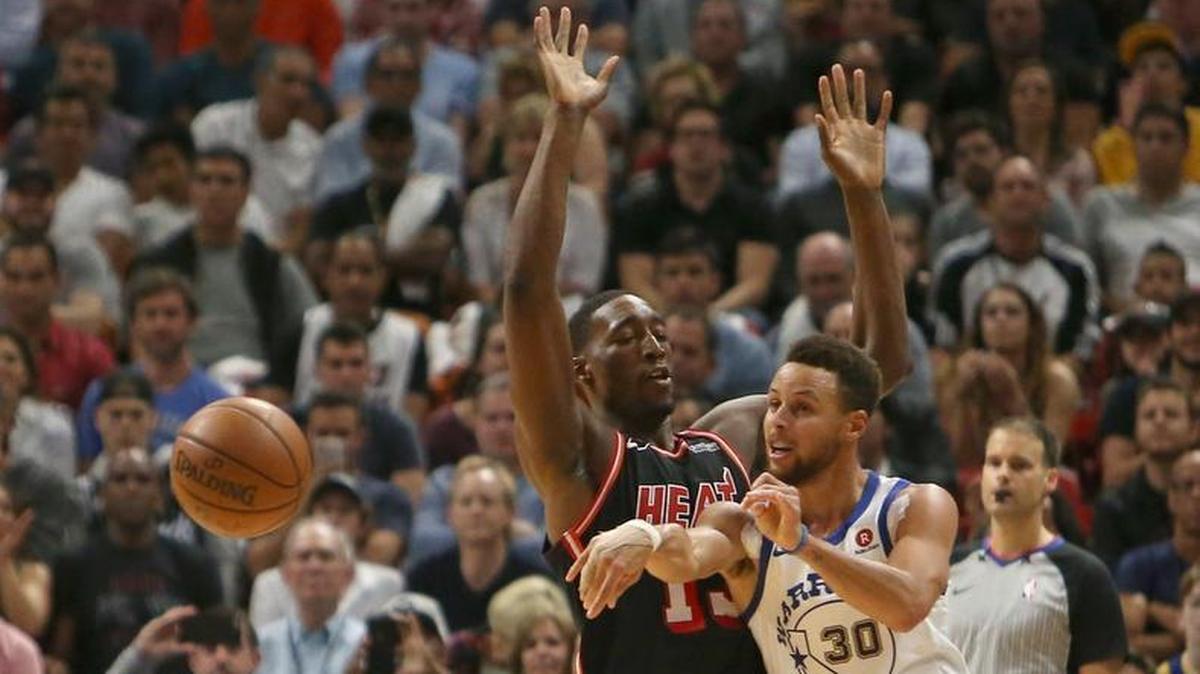 Golden State Warriors guard Stephen Curry passes the ball against Miami Heat forward Bam Adebayo during the second quarter of an NBA basketball game at the AmericanAirlines Arena in Miami on Sunday, Dec. 3, 2017.