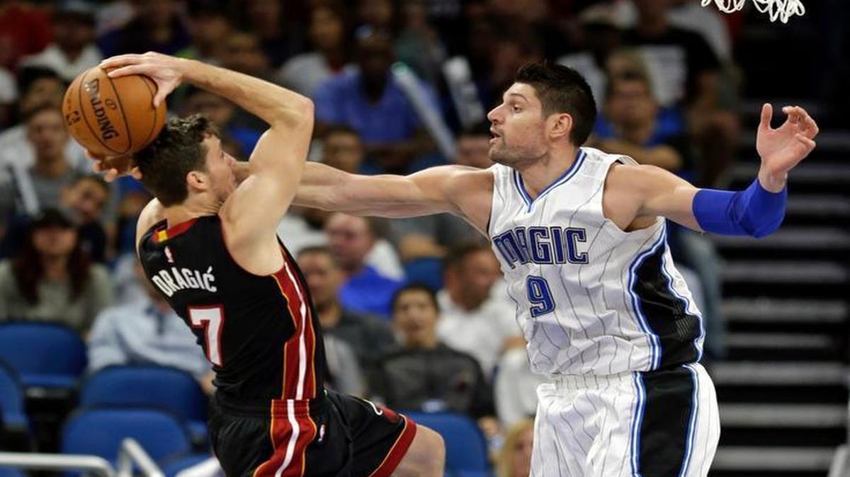 Orlando Magic's Nikola Vucevic (9) fouls Miami Heat's Goran Dragic (7) as he goes up for a shot during the second half of an NBA basketball game, Wed., Oct. 26, 2016, in Orlando, Fla. Miami won 108-96.