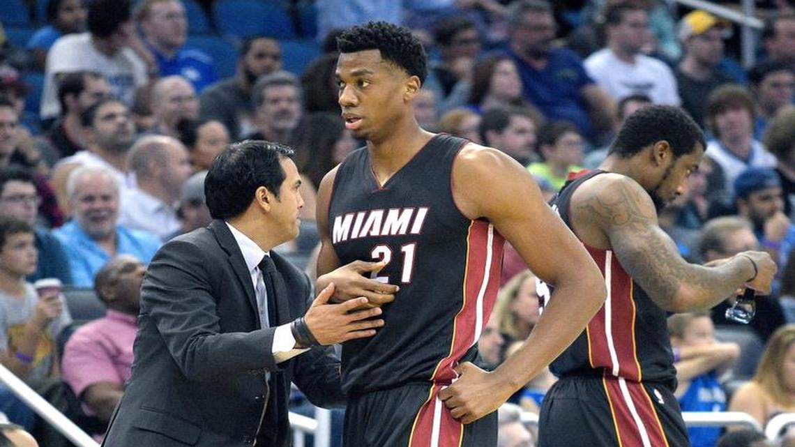 Miami Heat center Hassan Whiteside (21) is met by head coach Erik Spoelstra, left, after being replaced by forward Amar'e Stoudemire, right, during the first half of an NBA basketball game against the Orlando Magic in Orlando, Fla., Saturday, Dec. 26, 2015.