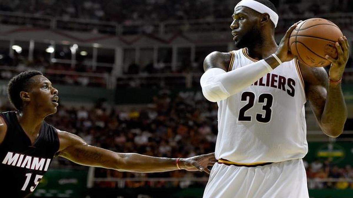 
LeBron James of the Cleveland Cavaliers drives against Mario Chalmers of the Miami Heat at Arena HSBC on October 11, 2014 in Rio de Janeiro, Brazil. 
