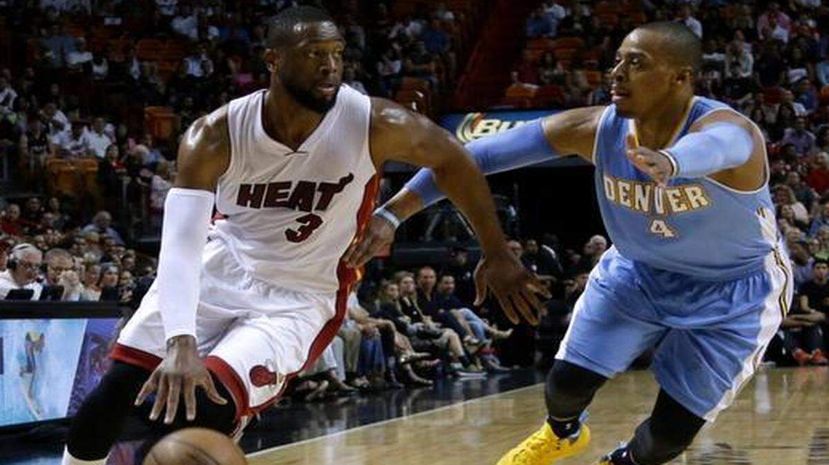 
Heat guard Dwyane Wade, left, drives around the Nuggets’ Randy Foye during the first half of Friday’s game at AmericanAirlines Arena. 
