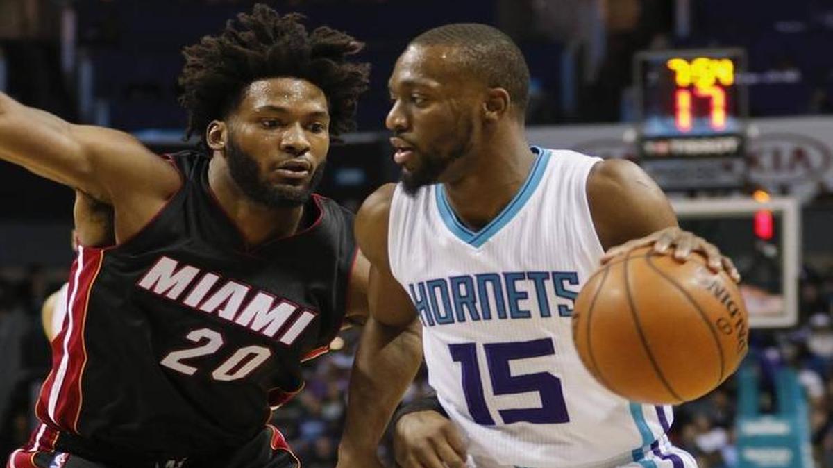 Charlotte Hornets guard Kemba Walker, right, drives against Miami Heat forward Justise Winslow during the first half of an NBA basketball game in Charlotte, N.C., Thurs., Dec. 29, 2016.