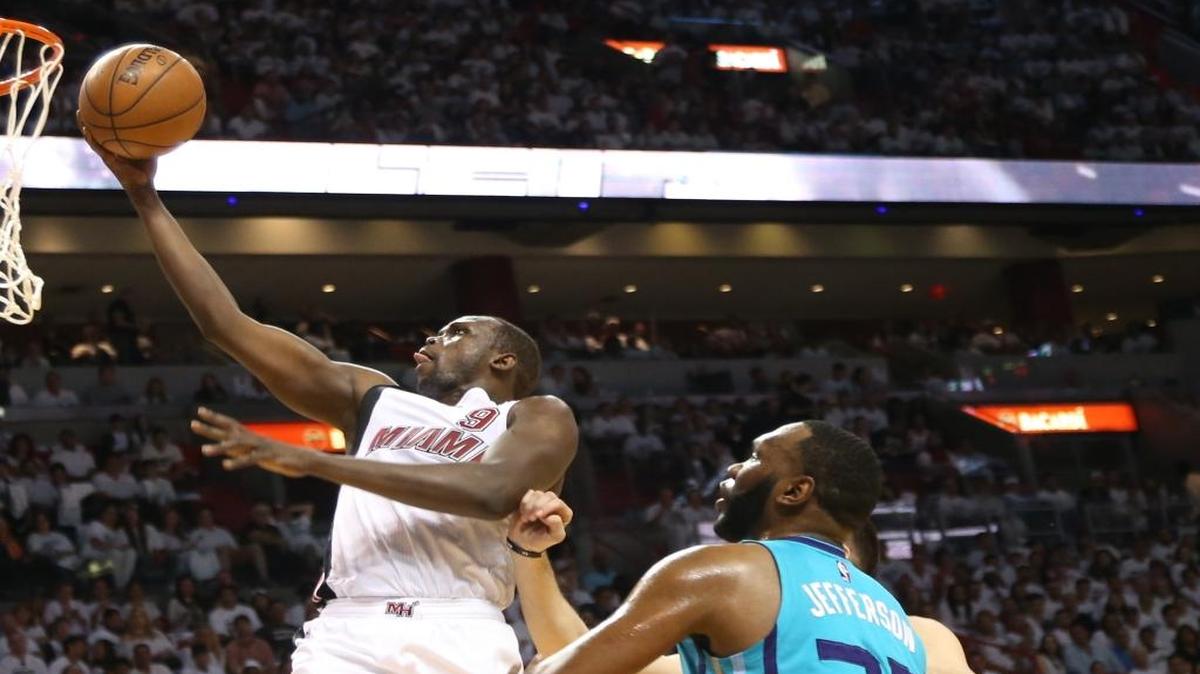 Loul Deng, left, drives to the basket, penetrating Hornets' defense in the first half on Sunday April 17.