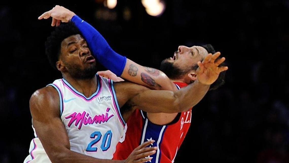 Miami Heat's Justise Winslow (20) and Philadelphia 76ers' Marco Belinelli (18) collide while reaching for a loose ball in the first half of an NBA basketball game, Wednesday, Feb. 14, 2018, in Philadelphia.