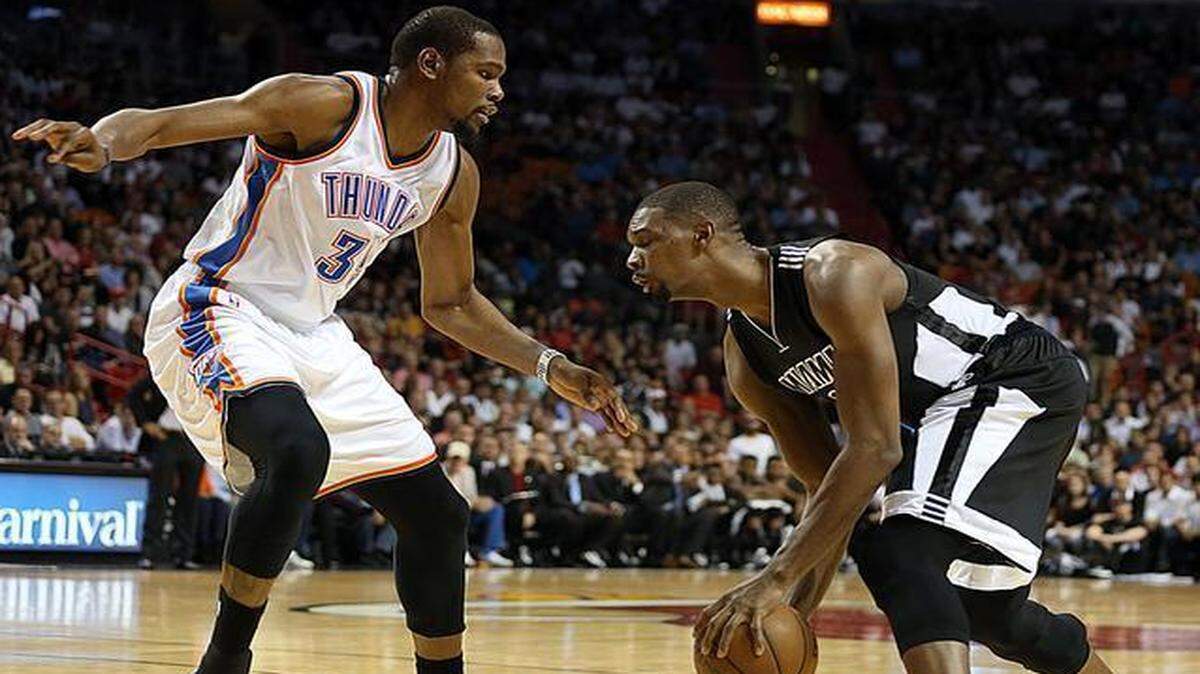 
Miami Heat forward-center Chris Bosh drives to the basket against the Thunder’s Kevint Durant at AmericanAirlines Arena in Miami on Tuesday, Jan. 20, 2015.
