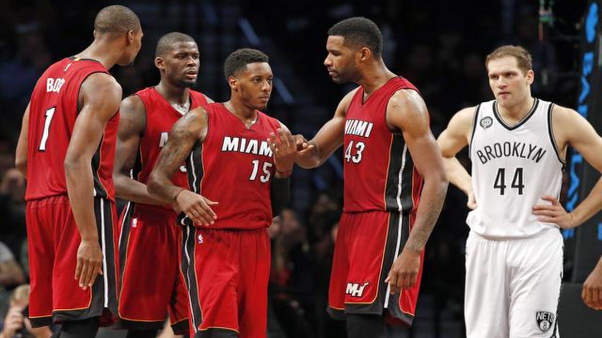 
Teammates, including Miami Heat forward Shawne Williams (43) congratulates Heat guard Mario Chalmers (15), who scored 22 points in the game, during a timeout in the fourth quarter of an NBA basketball game against the Brooklyn Nets at the Barclays Center, Monday, Nov. 17, 2014, in New York. Brooklyn Nets guard Bojan Bogdanovic (44), the Nets high scorer also with 22 points, reacts, right. 

