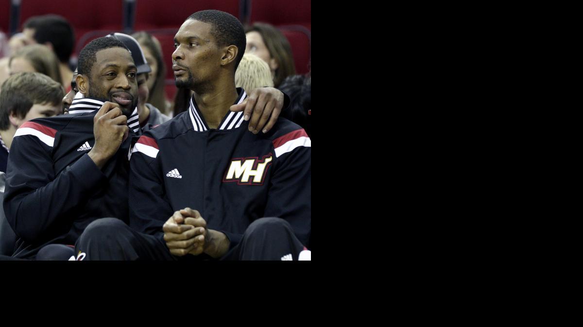 
Miami Heat's Dwyane Wade, left, talks with Chris Bosh on the bench during the fourth quarter of an NBA basketball game against the Houston Rockets Saturday, Jan. 3, 2015, in Houston. The Rockets won 115-79. 
