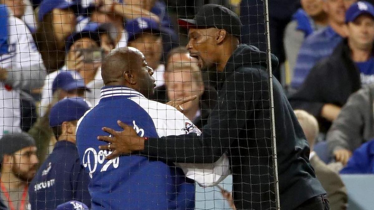 Minority Los Angeles Dodgers owner Earvin 'Magic' Johnson Jr. (L) greets NBA player Chris Bosh during game six of the 2017 World Series between the Houston Astros and the Los Angeles Dodgers at Dodger Stadium on Oct. 31, 2017, in Los Angeles, California.