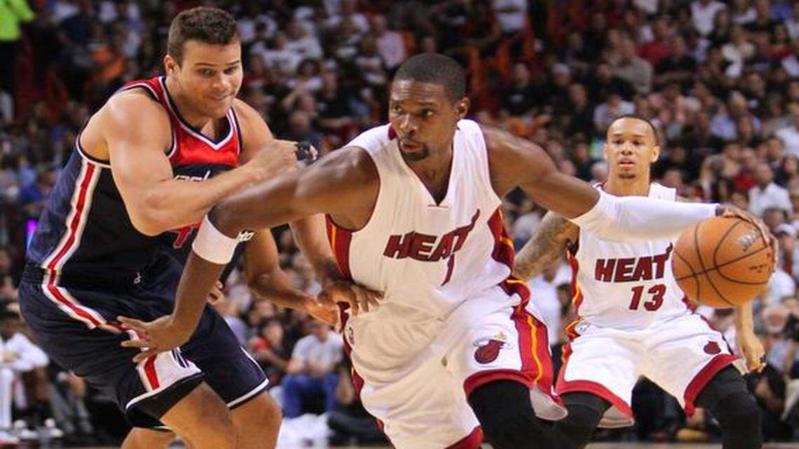 Miami Heat center Chris Bosh drives against Washington Wizards forward Kris Humphries during the third quarter of the season opening NBA game at the AmericanAirlines Arena in Miami on Wednesday, October 29, 2014.
