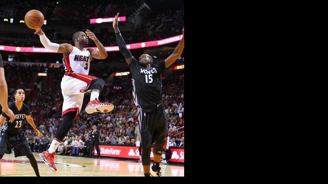 
Miami Heat guard Dwyane Wade passes the ball against against Minnesota Timberwolves forward Shabazz Muhammad during the fourth quarter of an NBA basketball game at the AmericanAirlines Arena in Miami on Saturday, November 8, 2014.
