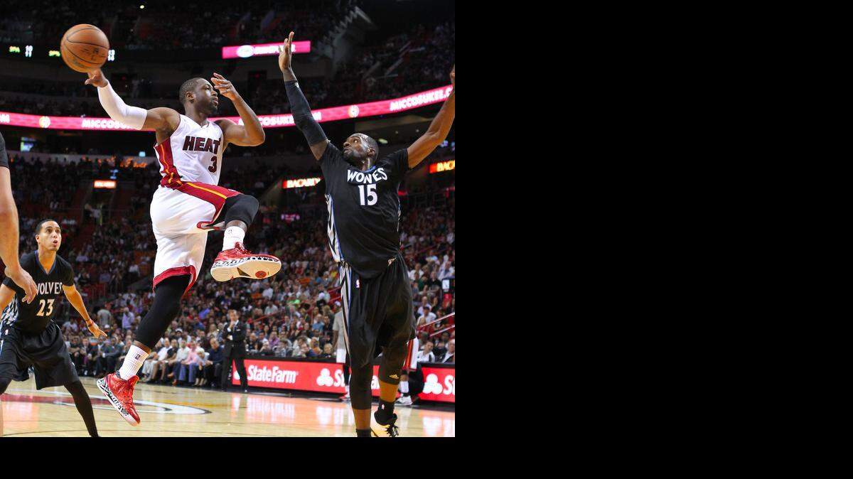 
Miami Heat guard Dwyane Wade passes the ball against against Minnesota Timberwolves forward Shabazz Muhammad during the fourth quarter of an NBA basketball game at the AmericanAirlines Arena in Miami on Saturday, November 8, 2014.
