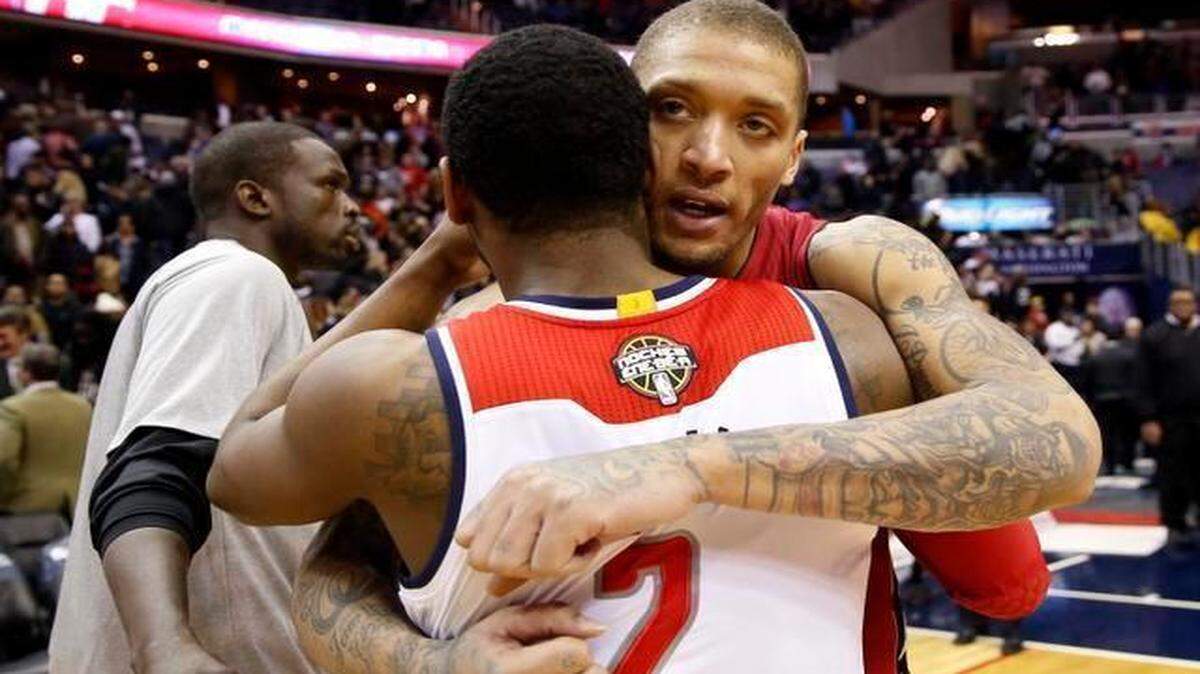 
Washington Wizards guard John Wall (2) embraces Miami Heat forward Michael Beasley (30) after an NBA basketball game Friday, March 6, 2015, in Washington. The Wizards won 99-97. 
