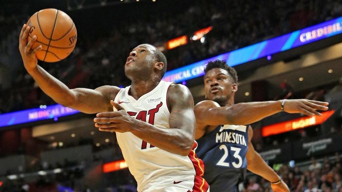Miami Heat guard Dion Waiters leaps past Minnesota Timberwolves guard Jimmy Butler in the first quarter at AmericanAirlines Arena in Miami, Florida, October 30, 2017.