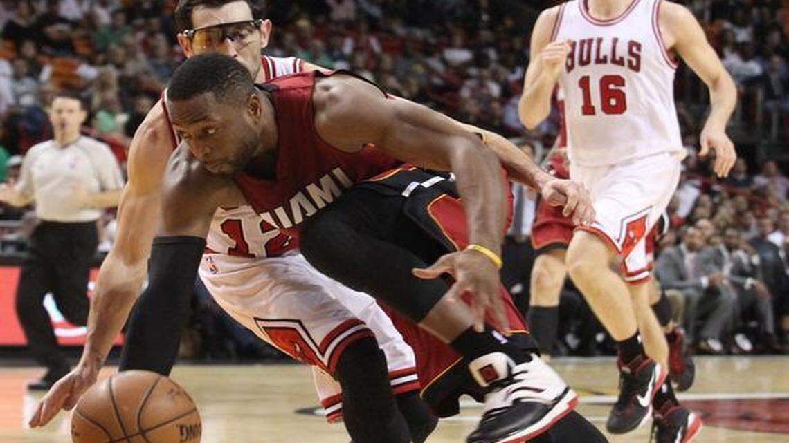 
Miami Heat guard Dwyane Wade drives to the basket against Chicago Bulls guard Kirk Hinrich in the fourth quarter during their game at AmericanAirlines Arena on Sunday, Dec. 14, 2014.
