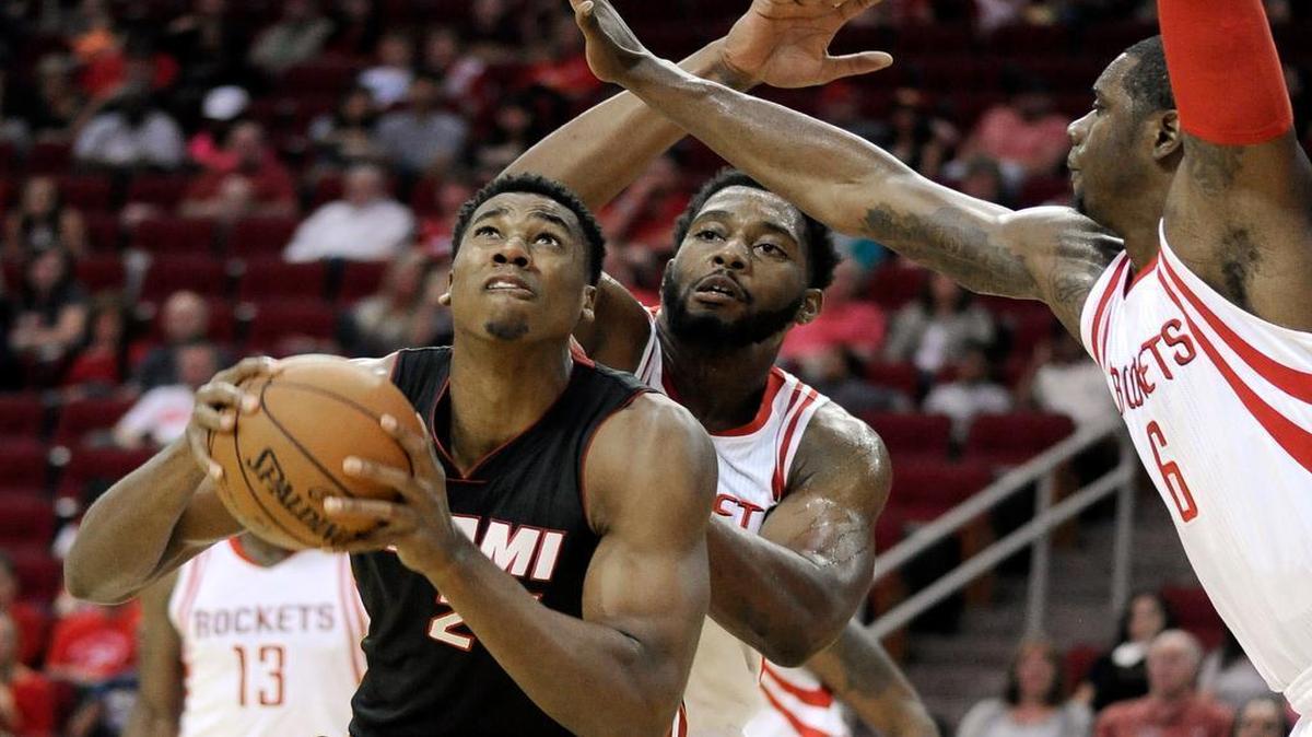 
The Heat's Hassan Whiteside takes the ball strong to the basket against the Rockets’ Terrence Jones (6) and Joshua Smith on Saturday in Houston.
