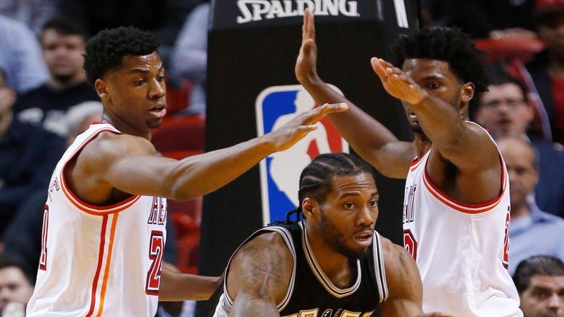 San Antonio Spurs forward Kawhi Leonard, center, looks for an opening past Miami Heat center Hassan Whiteside, left, and forward Justise Winslow during the first half of an NBA basketball game, Tuesday, Feb. 9, 2016, in Miami. Leonard scored 23 points as the Spurs defeated the Heat 119-101.