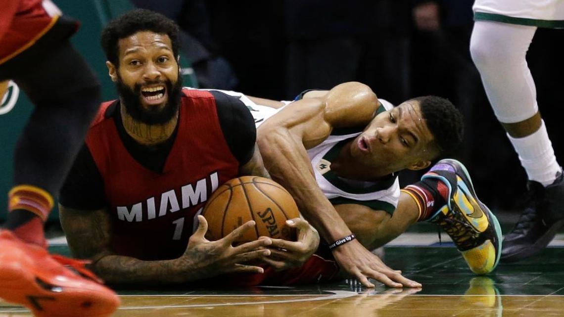 Milwaukee Bucks' Giannis Antetokounmpo and Miami Heat's James Johnson wrestle for a loose ball during the second half of an NBA basketball game Wed., Feb. 8, 2017, in Milwaukee.