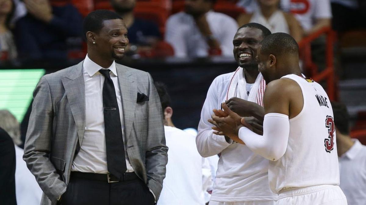 Miami Heat forward Chris Bosh, left, jokes with forward Luol Deng, center, and guard Dwyane Wade (3) during the second half of Game 1 of a first-round NBA basketball playoff series against the Charlotte Hornets, Sunday, April 17, 2016, in Miami.