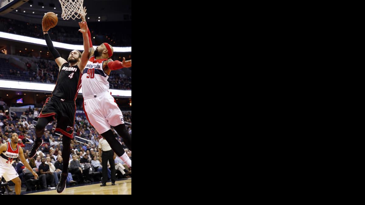 
Miami Heat forward Josh McRoberts (4) shoots in front of Washington Wizards forward Drew Gooden (90) in the first half of an NBA basketball game, Monday, Dec. 1, 2014, in Washington. 
