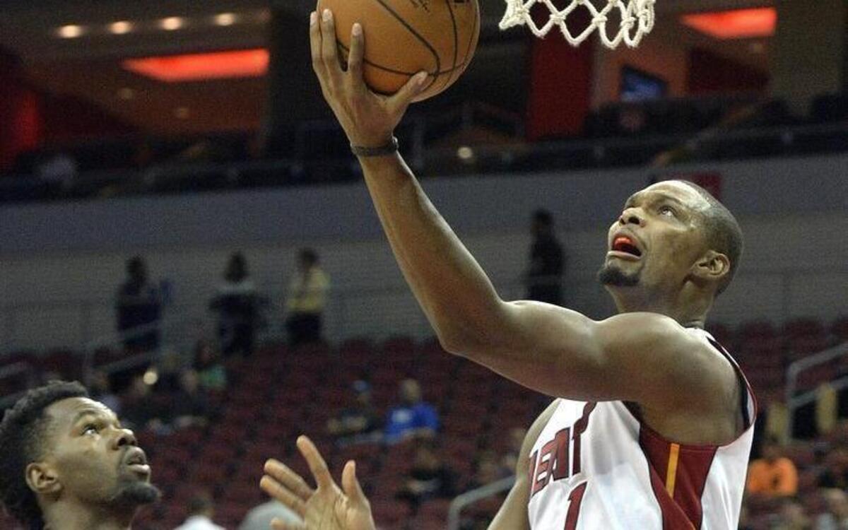 
Miami Heat forward Chris Bosh goes in for a layup past the defense of Orlando Magic's Dewayne Dedmon during the first half of an NBA preseason basketball game Wednesday, Oct. 7, 2015, in Louisville, Ky. 
