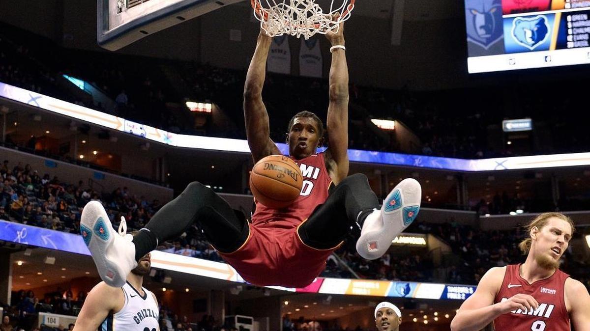 Miami Heat forward Josh Richardson (0) hangs from the rim after dunking in the first half of an NBA basketball game against the Memphis Grizzlies on Monday, Dec. 11, 2017, in Memphis, Tenn.