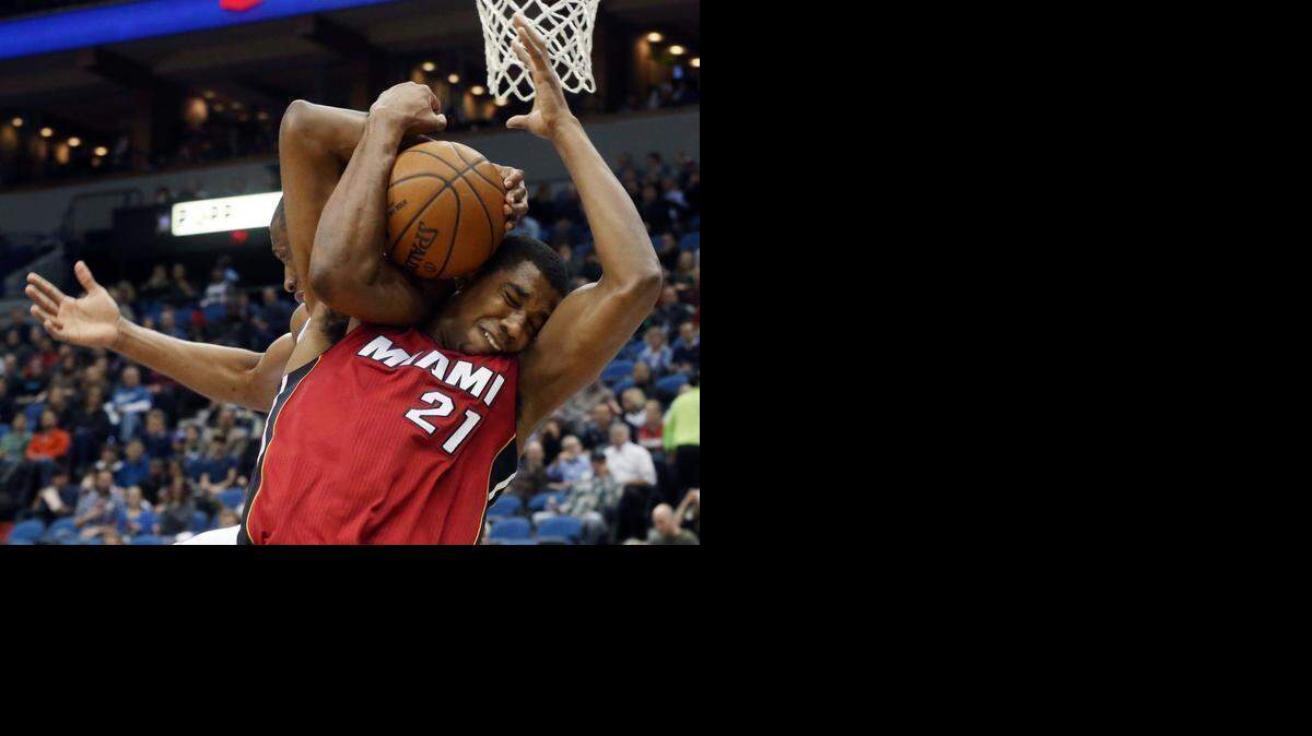 
Minnesota Timberwolves forward Andrew Wiggins, left, and Miami Heat center Hassan Whiteside (21) struggle for possession of a rebound in the first quarter of an NBA basketball game in Minneapolis on Feb. 4, 2015. A jump ball was called on the play.
