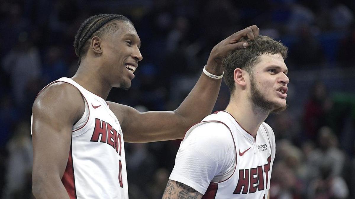 Miami Heat forward Josh Richardson (0) congratulates guard Tyler Johnson (8) at the end of an NBA basketball game against the Orlando Magic, Saturday, Dec. 30, 2017, in Orlando, Fla.