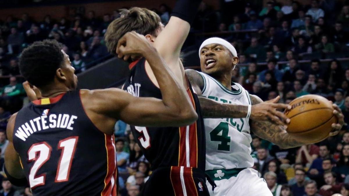 Boston Celtics guard Isaiah Thomas (4) looks to pass the ball against the defense of Miami Heat forward Luke Babbitt (5) and center Hassan Whiteside (21) in the first quarter of an NBA basketball game, Fri., Dec. 30, 2016, in Boston.